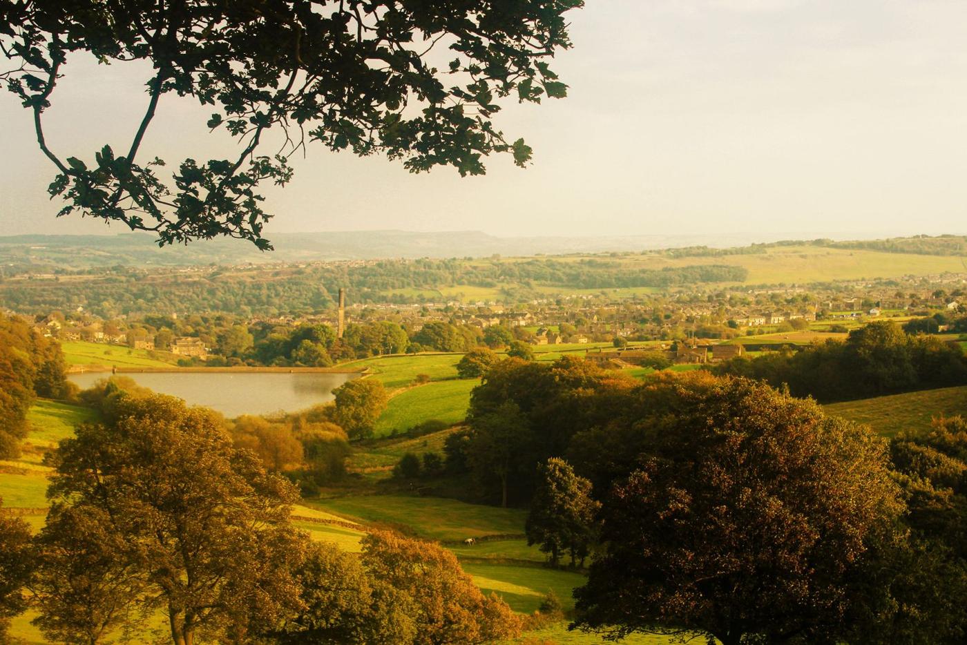 Lancashire countryside with fields and a reservoir in warm evening light